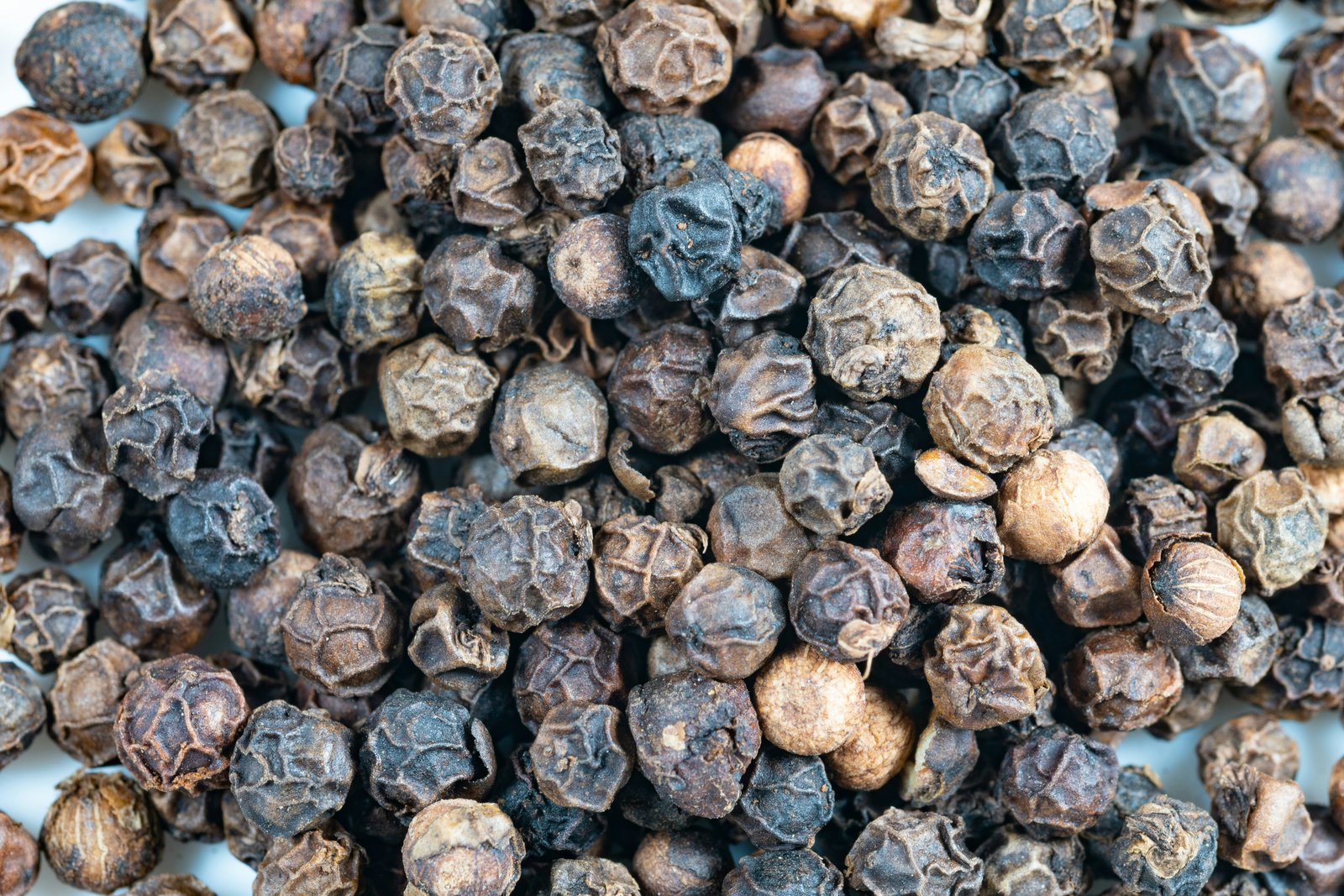 Close-up pile of whole black peppercorns